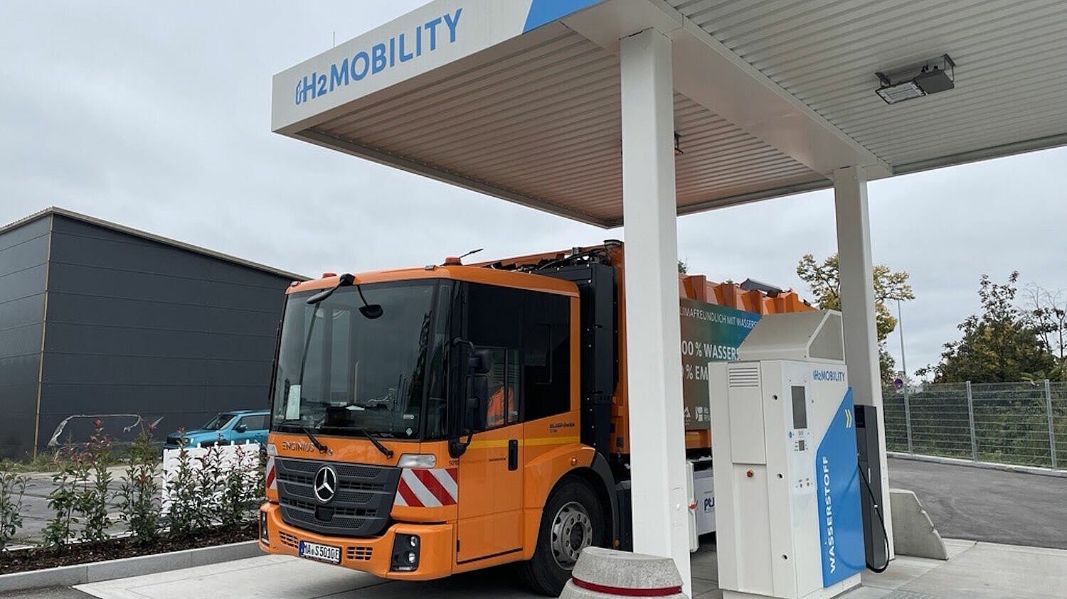 Ein Brennstoffzellen-Abfallsammelfahrzeug steht an einer H2-Tankstelle